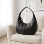 Borsa hobo in pelle martellata nera su una poltrona in lino