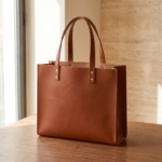 Borsa tote in pelle cognac su un tavolo in noce