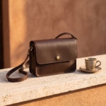Borsa a tracolla in pelle testa di moro su un ripiano in travertino