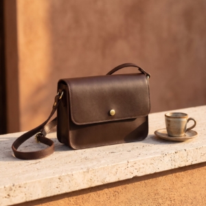 Borsa a tracolla in pelle testa di moro su un ripiano in travertino