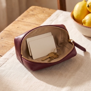 Bustina in pelle bordeaux aperta con carte e chiavi