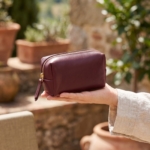 Bustina in pelle bordeaux tenuta in mano