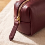 Dettaglio della zip in ottone della bustina bordeaux