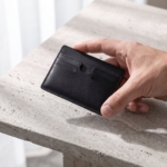 Porta carte in pelle nera tenuto in mano